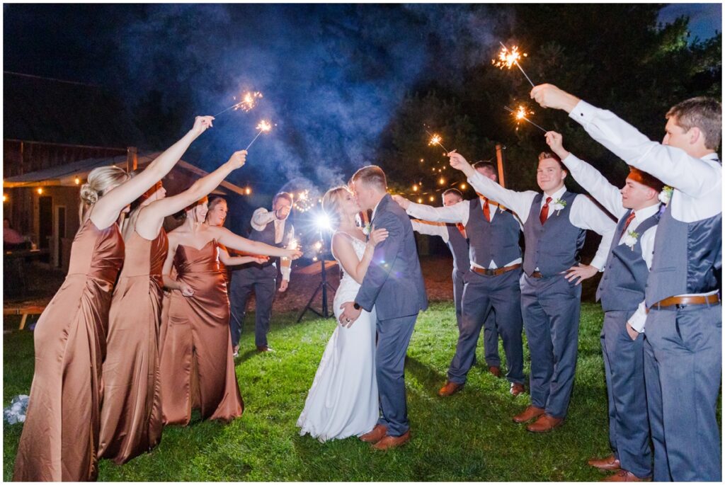 bride and groom with their bridal party doing a sparkler exit